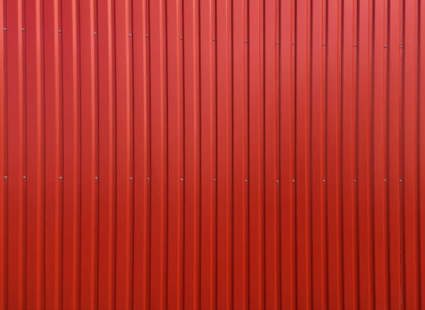 Building wall clad in red plastic siding Background and texture. Modern building material. Red bright aluminum sidin, painted with paint. Wall covering for office buildings and warehouses clad stock pictures, royalty-free photos & images