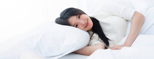 istock attractive Beautiful young asian woman sleeping while lying in her bed and relaxing comfortably. stretching wake up for work or the day off. Concept of pleasant and rest reinstatement for active life. 1314017507