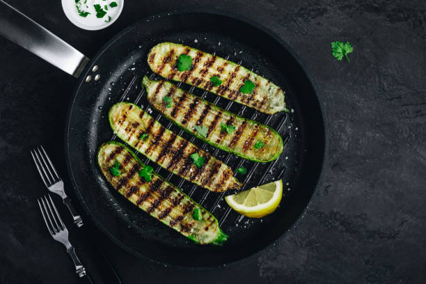 istock Grilled zucchini slices in cast iron pan on dark stone or concrete background 1314019706