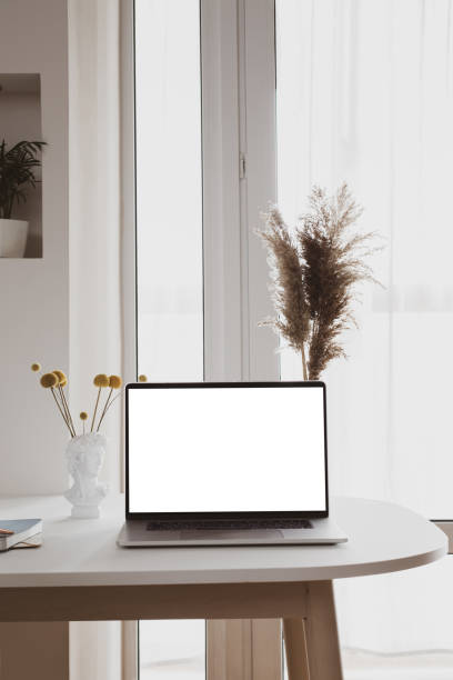 istock Laptop with blank white screen in office desk interior. Stylish workplace mockup. 1314022766