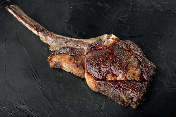 istock Tomahawk beef steak Grilled with spices, on black stone background 1314024667