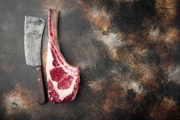 istock Tomahawk beef steak raw, and old butcher cleaver knife, on old dark rustic background, top view flat lay, with copy space for text 1314024836