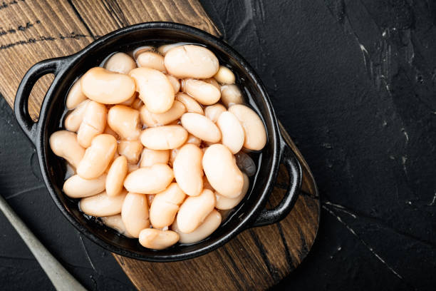 istock White canned beans, in bowl, on black stone background, top view flat lay, with copy space for text 1314025124