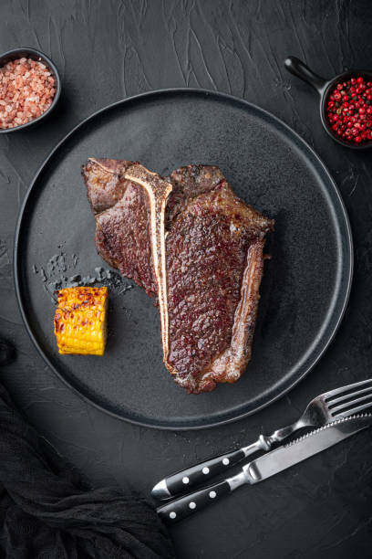 istock T-bone grilled beef steak with spices and herbs , on plate, top view flat lay 1314025472