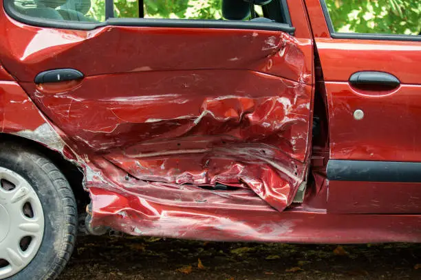 Detail of red car damaged on traffic accident