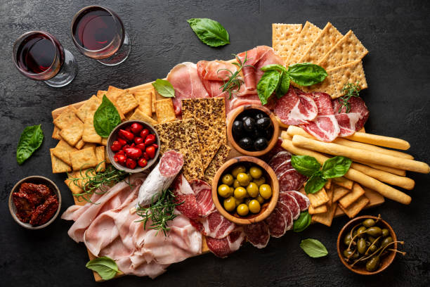 Appetizers with differents antipasti Appetizers with differents antipasti, charcuterie, snacks and red wine. Sausage, ham, tapas, olives and crackers for buffet party. Top view, flat lay charcuterie stock pictures, royalty-free photos & images