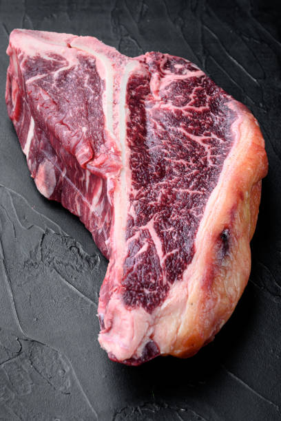 istock Raw fresh dry aged beef T-bone steak, on black stone background 1314029390