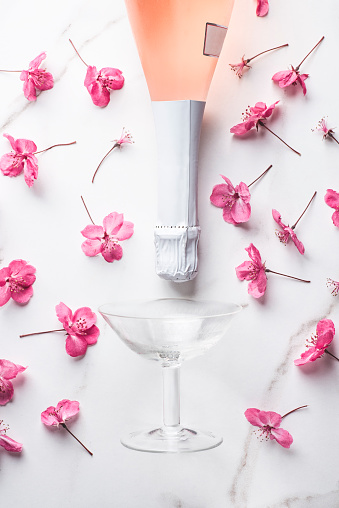 Rose sparking wine in the  summer-spring background with beautiful soft flowers. Summer drink for party, wine shop or wine tasting concept, flat lay