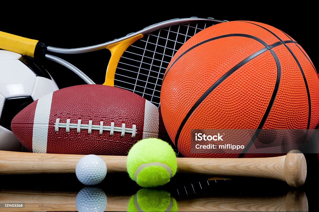 Assorted Sports Equipment on Black A group of assorted sports equipment on a black background including a tennis raquet, basketball, baseball bat and ball, soccer or football and a golf ball Sports Equipment Stock Photo