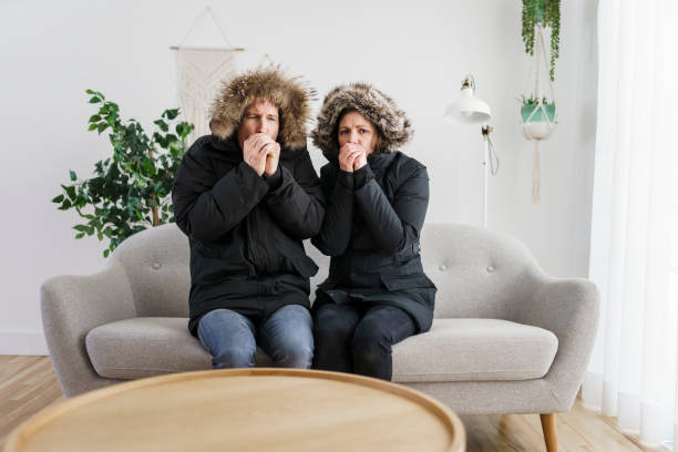 istock Couple have cold on the sofa at home with winter coat 1314032972