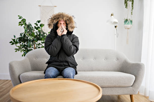istock Man With Warm Clothing Feeling The Cold Inside House on the sofa 1314033038