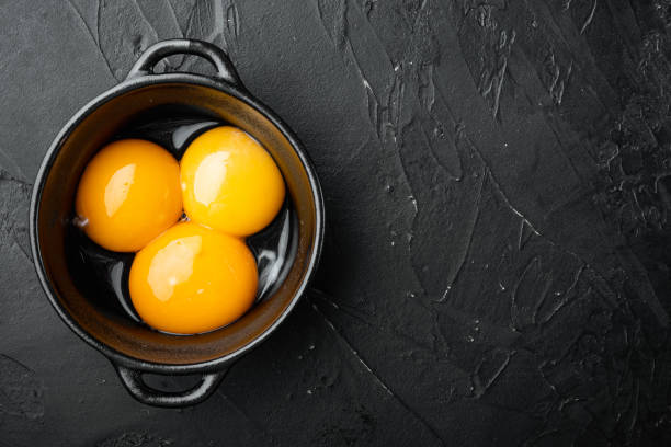 istock Bright yellow egg yolks, on black stone background, top view flat lay, with copy space for text 1314037556