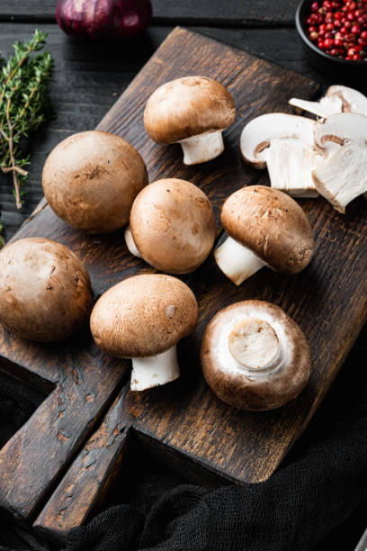 istock Royal champignons, Parisian champignons, on black wooden table background 1314038295