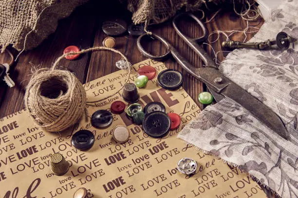 Photo of Sewing thread scissors buttons for seamstress on wooden background.