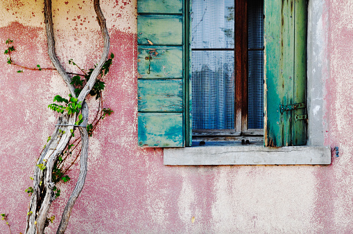 Old window and pink wall in Burano, Italy