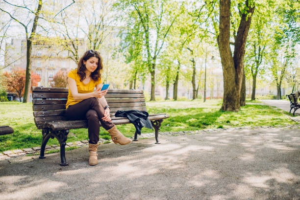 istock Woman checking social media on phone in a park 1314042017