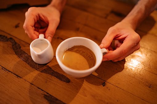 Barista making latte art in coffee, close up.