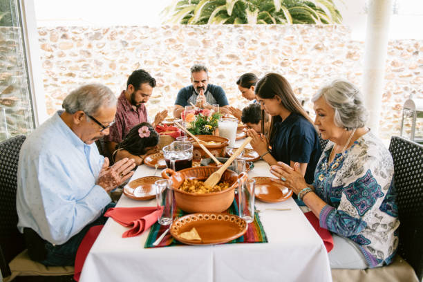 família multigeracional dizendo graça antes do jantar - family thanksgiving dinner praying - fotografias e filmes do acervo