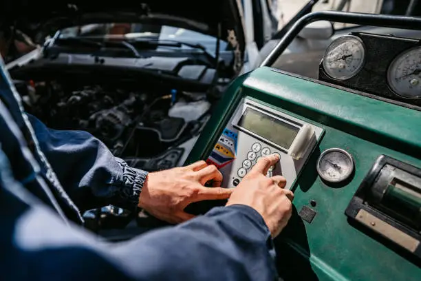 Photo of Auto mechanic filling the vehicle's air conditioning