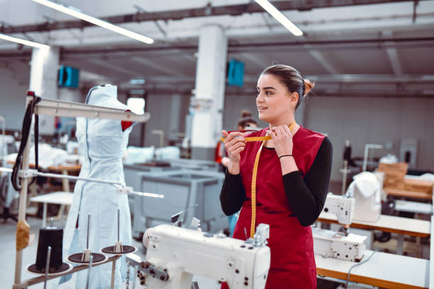 istock Smiling Female Textile Worker Checking Tape Measure While Working On Sewing Machine 1314048330