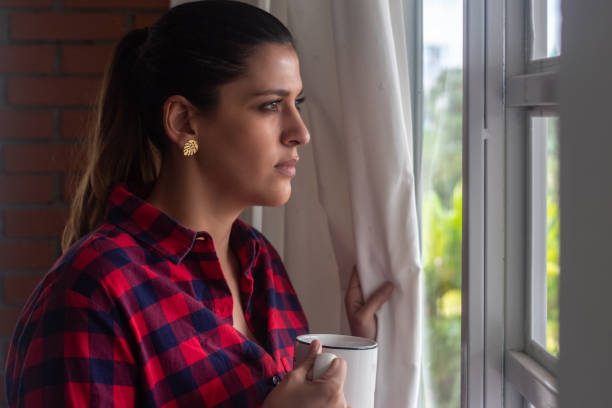 istock Woman staring at the window during isolation 1314050533