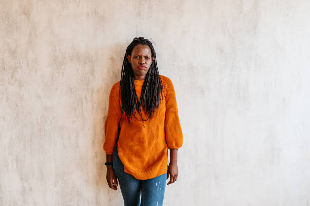 istock Frowning black woman standing against wall 1314051901