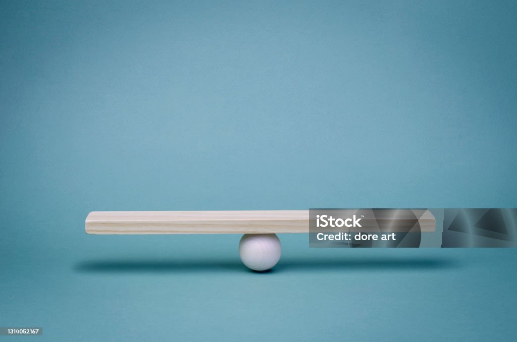 Stability, balance and equality in business partnerships in economic relations. Business finance concept. Wooden scales on a turquoise background. Seesaw Stock Photo