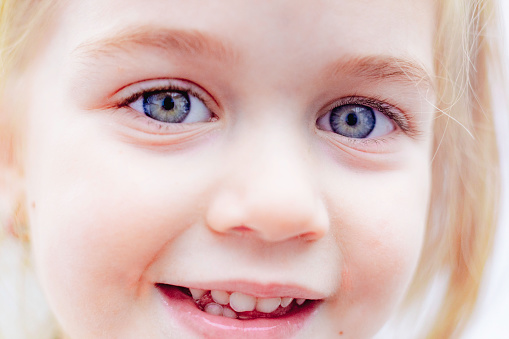 3-year-old child playing peekaboo, blowing kisses, and playing in the grass