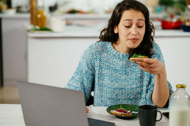 istock Young woman using laptop while breakfast at home. stock photo 1314056723