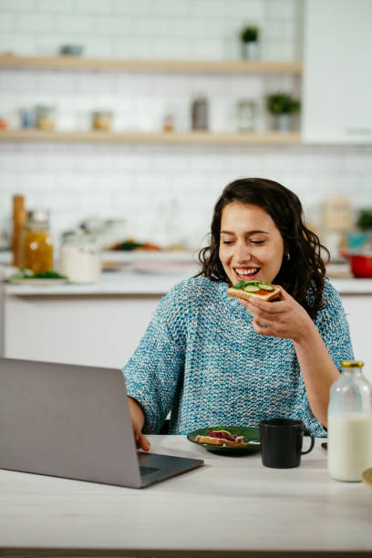 istock Young woman using laptop while breakfast at home. stock photo 1314056966