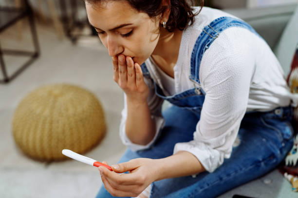 zaniepokojona kobieta trzymająca test ciążowy. zdjęcie stockowe - gynecological examination zdjęcia i obrazy z banku zdjęć