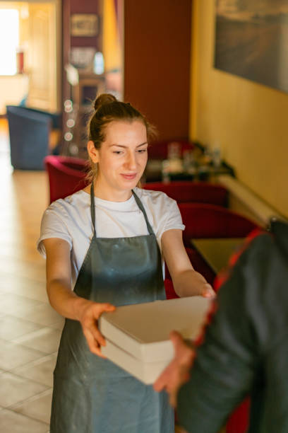 istock Waitress giving pizza box to customer 1314058247