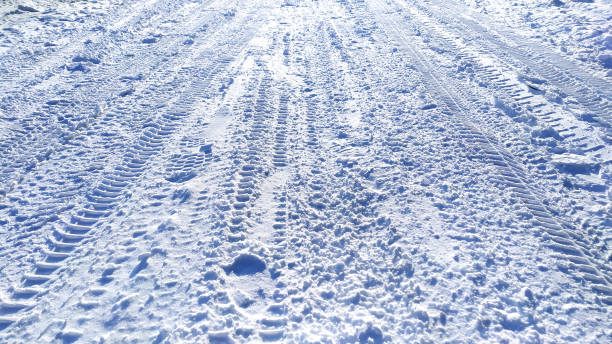 istock Tire and foot marks on a snowy road 1314058567