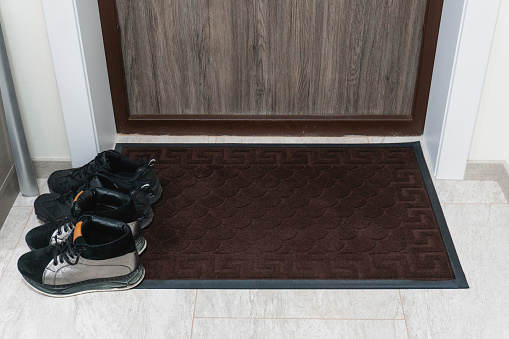 Mat with shoes near entrance door apartment