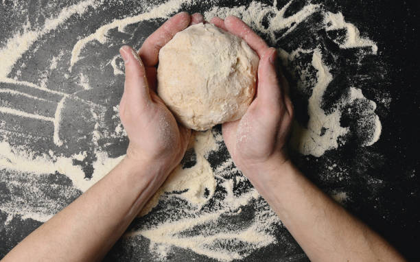 padeiro faz pão, macarrão ou massa de pizza vista de cima. - bread kneading making human hand - fotografias e filmes do acervo