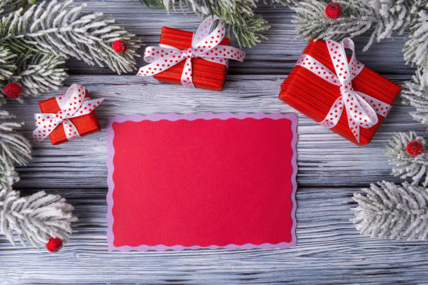 istock Blank red card template with red gift boxes and Christmas decoration on light wooden background 1314063914