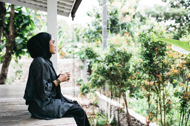 istock Young hijab woman sitting on floor on backyard 1314067796