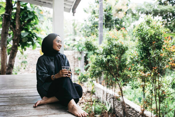 Young hijab woman sitting on floor on backyard