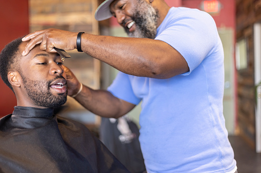 An man getting his haircut at a barber shop