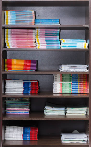 Bookcase with textbooks and notebooks neatly laid out on the shelf.