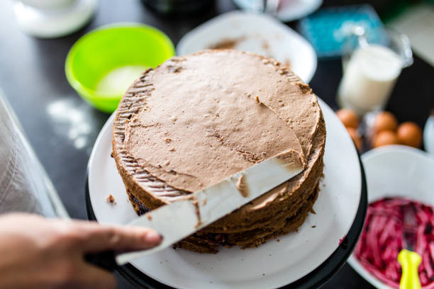 istock Woman putting whipped cream on cake 1314073751