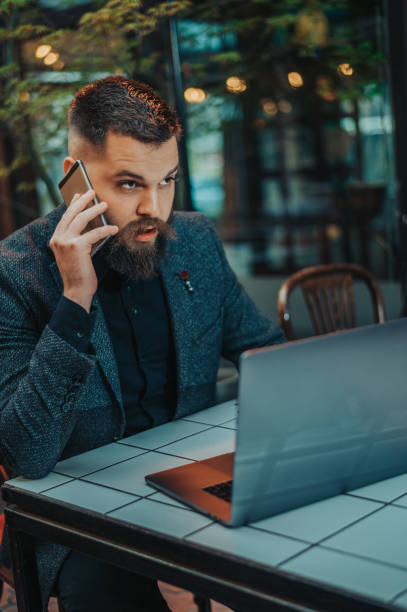 istock Businessman using a smartphone and a laptop in a coffee shop 1314073791