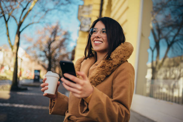 istock Hispanic woman using a smartphone and drinking coffee 1314073812