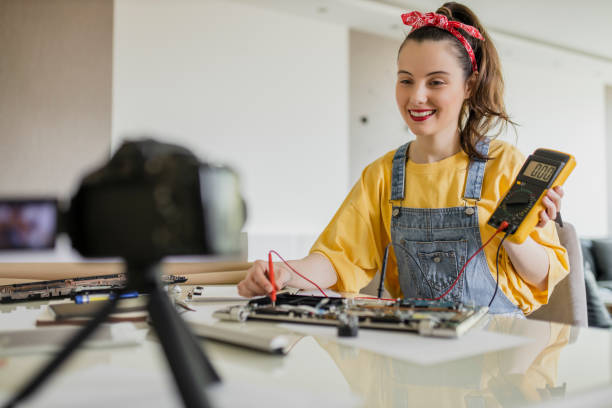 istock Beautiful woman filming tutorial about repair works on laptop 1314076064