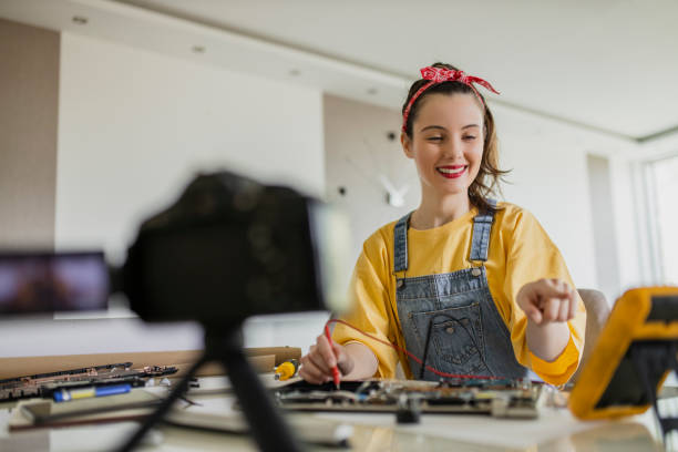 istock Beautiful woman filming tutorial about repair works on laptop 1314077513