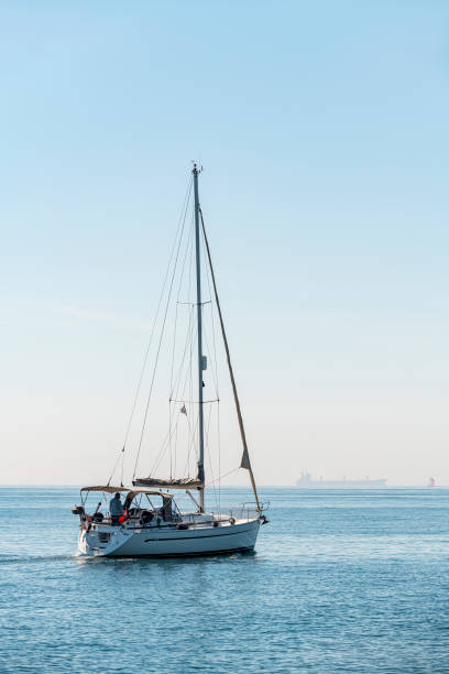 velero que se aleja de nosotros en un día soleado - clear sky vacations vertical saturated color fotografías e imágenes de stock