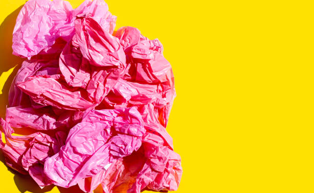 istock Red crumpled plastic bags on yellow background. 1314086666