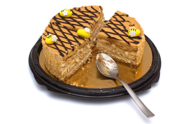sliced honey cake with edible bees on top, the top of the cake is decorated in a cage of chocolate lines. concept for birthday, meeting with parents, holidays. isolated on white background.