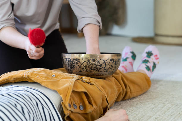 weibliche erhalten tibetische klangschale massage und klangtherapie aus traditionellen nepal medizinischen praxis - music wellbeing rin gong bowl stock-fotos und bilder