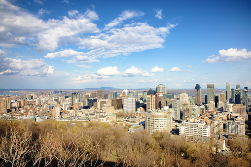 Aerial downtown Montreal view looking towards the new skyscrapers and Saint-Lawrence River on a partly cloudy April day.